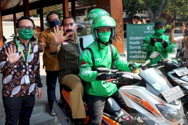 Ojol Grab Solo Gunakan Alat Proteksi Cegah COVID-19